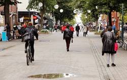 Gående og syklende mennesker med ryggsekk i gågate. Illustrasjonsfoto:  Roland Magnusson/IstockPhoto